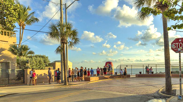 tourists standing in line in order to take picture at famous tourist attraction southernmost point. key west. florida usa